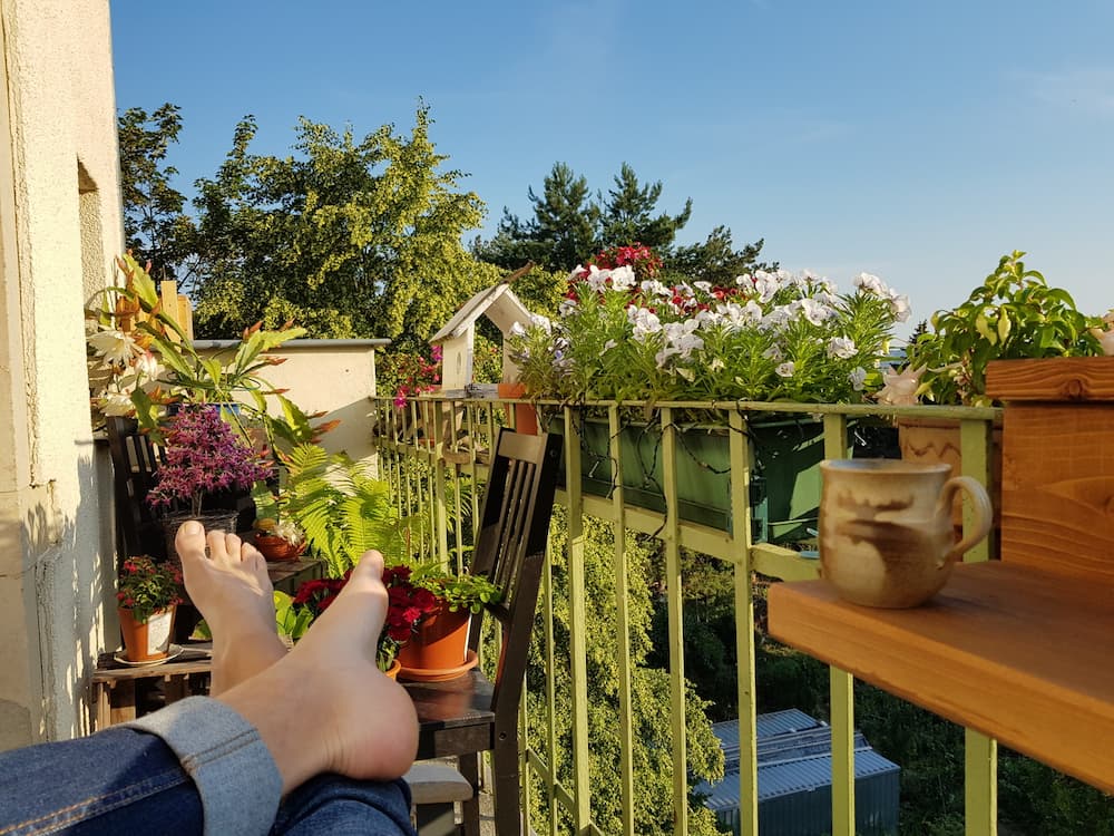 Person sitzt auf Balkon und sonnt sich